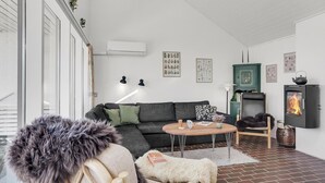 Ein gemütliches Wohnzimmer mit einer Couch, einem Couchtisch und einem Kamin.