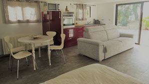 A compact living space with a dining area, kitchenette, and a sofa. - Bas de villa near Calanques de Cassis in quiet subdivision (Carnoux-en-Provence)