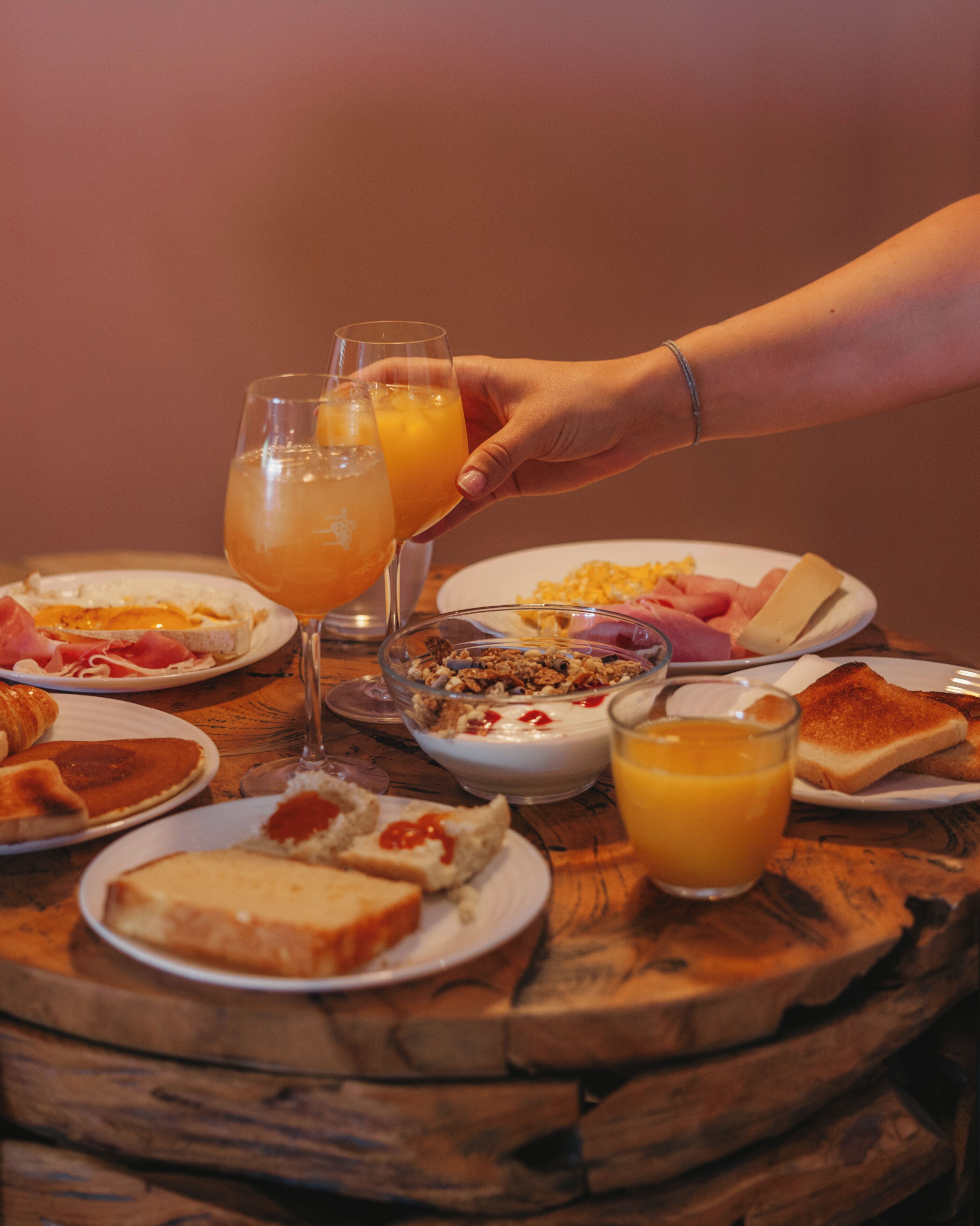Un desayuno con diversas opciones de comida y bebidas sobre una mesa de madera.