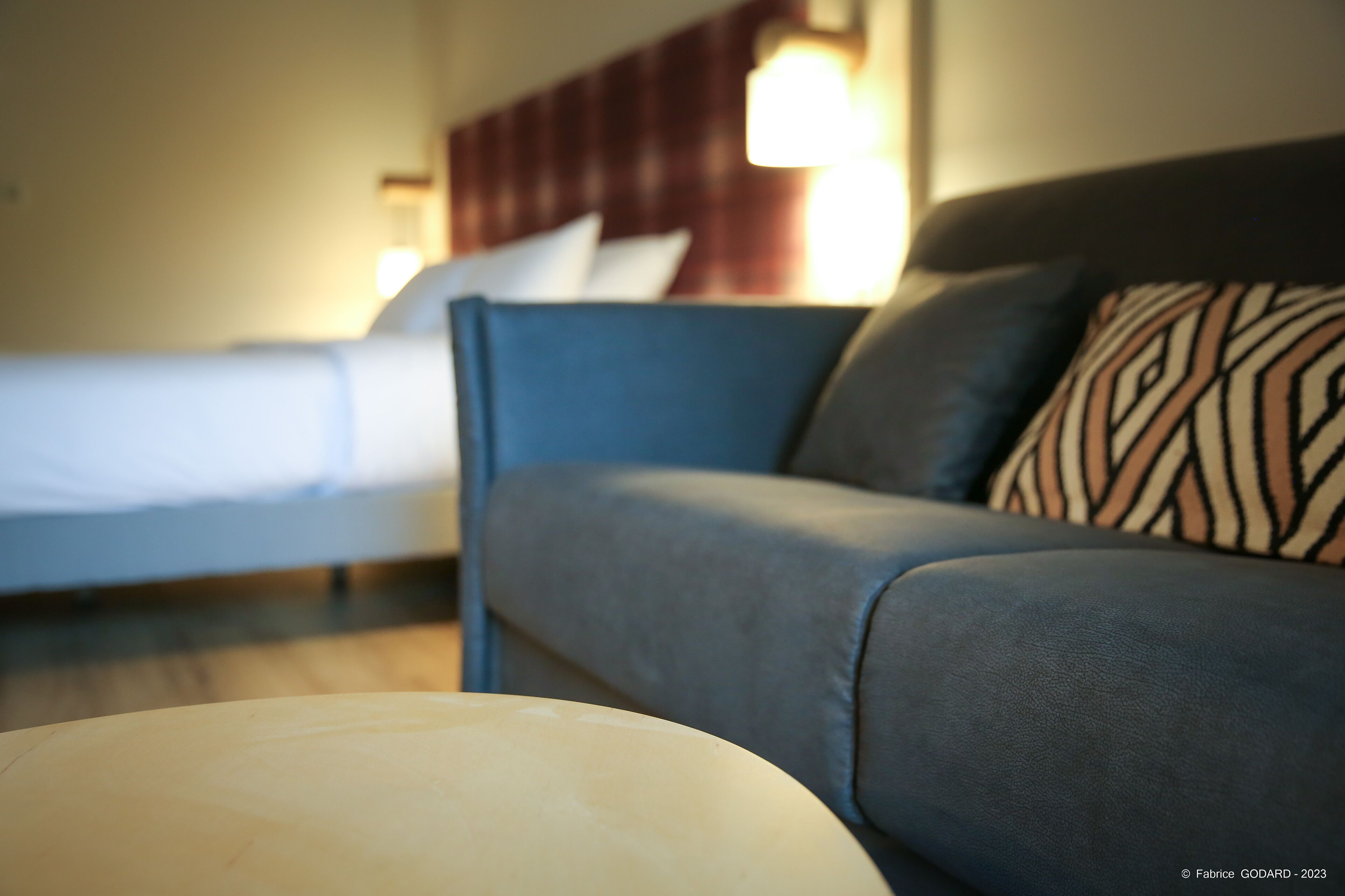 Una habitación de hotel con una cama, un sofá y una mesita de noche.