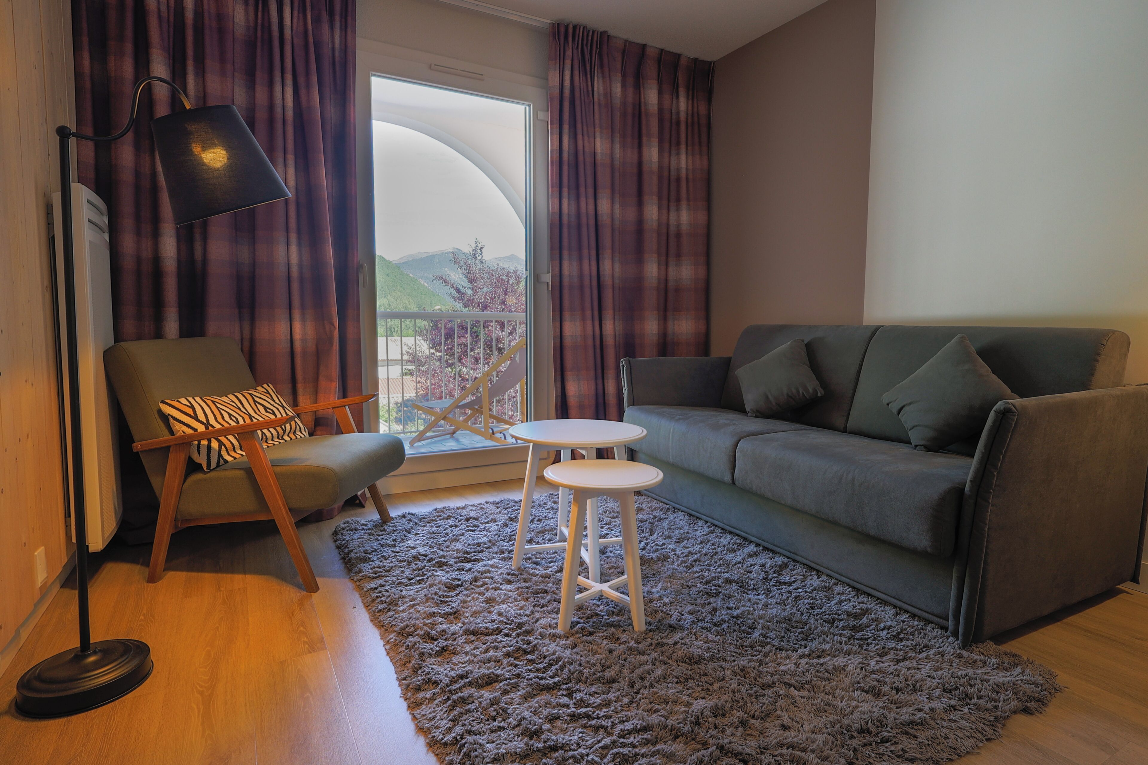 A living room with a sofa, a chair, a small table, and a lamp.