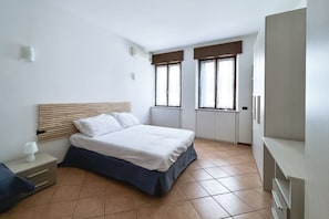 Une chambre à coucher avec un lit, une table de chevet et une armoire.