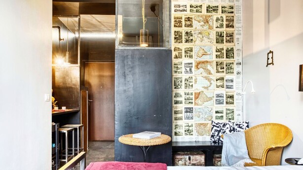 A modern bedroom with a large bed, a small round table, a bookshelf, and a wall with a collage of photographs. - Hosmate - Milano - Sammartini's Cave - Stazione Centrale (Milano)