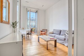A modern living room with a sofa, a coffee table, a desk, and a chair.