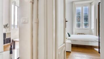 Een slaapkamer met een bed, een raam en een deur.