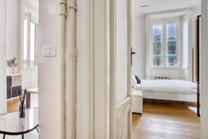 A bedroom with a bed, a window, and a door.