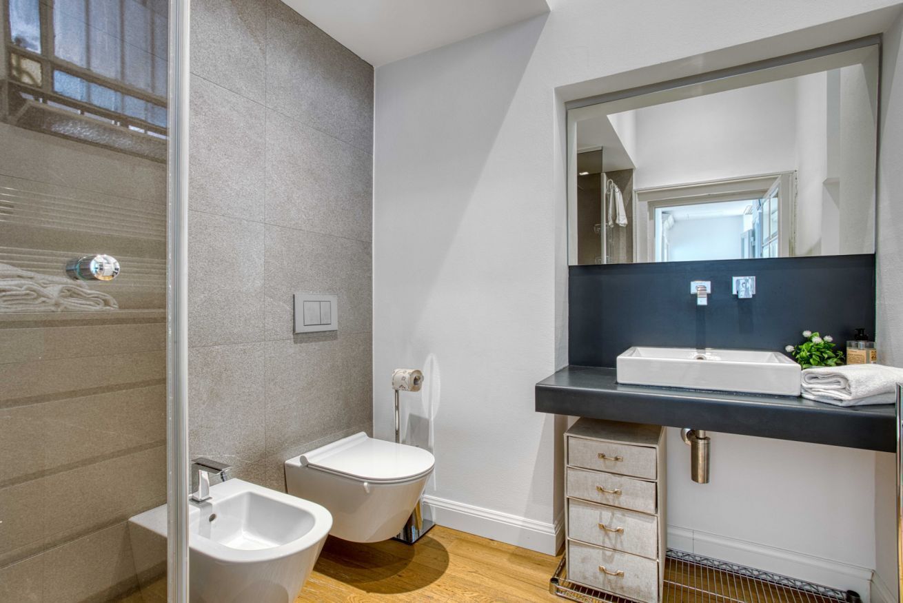A modern bathroom with a bidet, toilet, and sink.