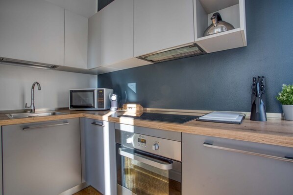 A modern kitchen with a microwave, oven, and built-in cabinets.
