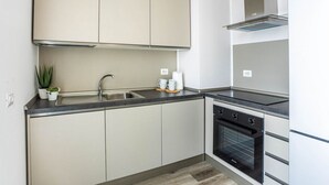 Een moderne keuken met een spoelbak, fornuis en kastjes.