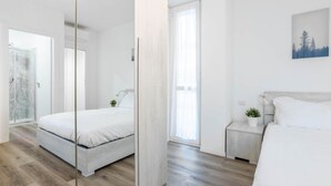 Een moderne slaapkamer met een bed, nachtkastje en raam.