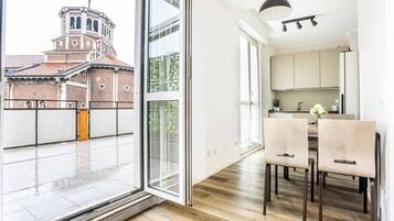 A modern kitchen with a dining area, large windows, and a view of a historic building.