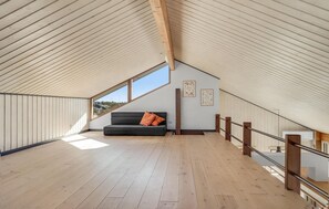 Relax in this cozy attic room with a bench and stunning views through the skylight.