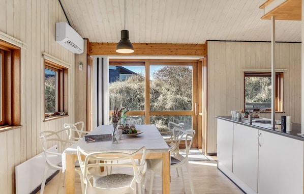 Enjoy meals in this dining area with a view, featuring a dining table, kitchen area, and pendant light.
