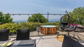 Une terrasse sur le toit avec des sièges extérieurs, un jacuzzi et une vue sur la mer.