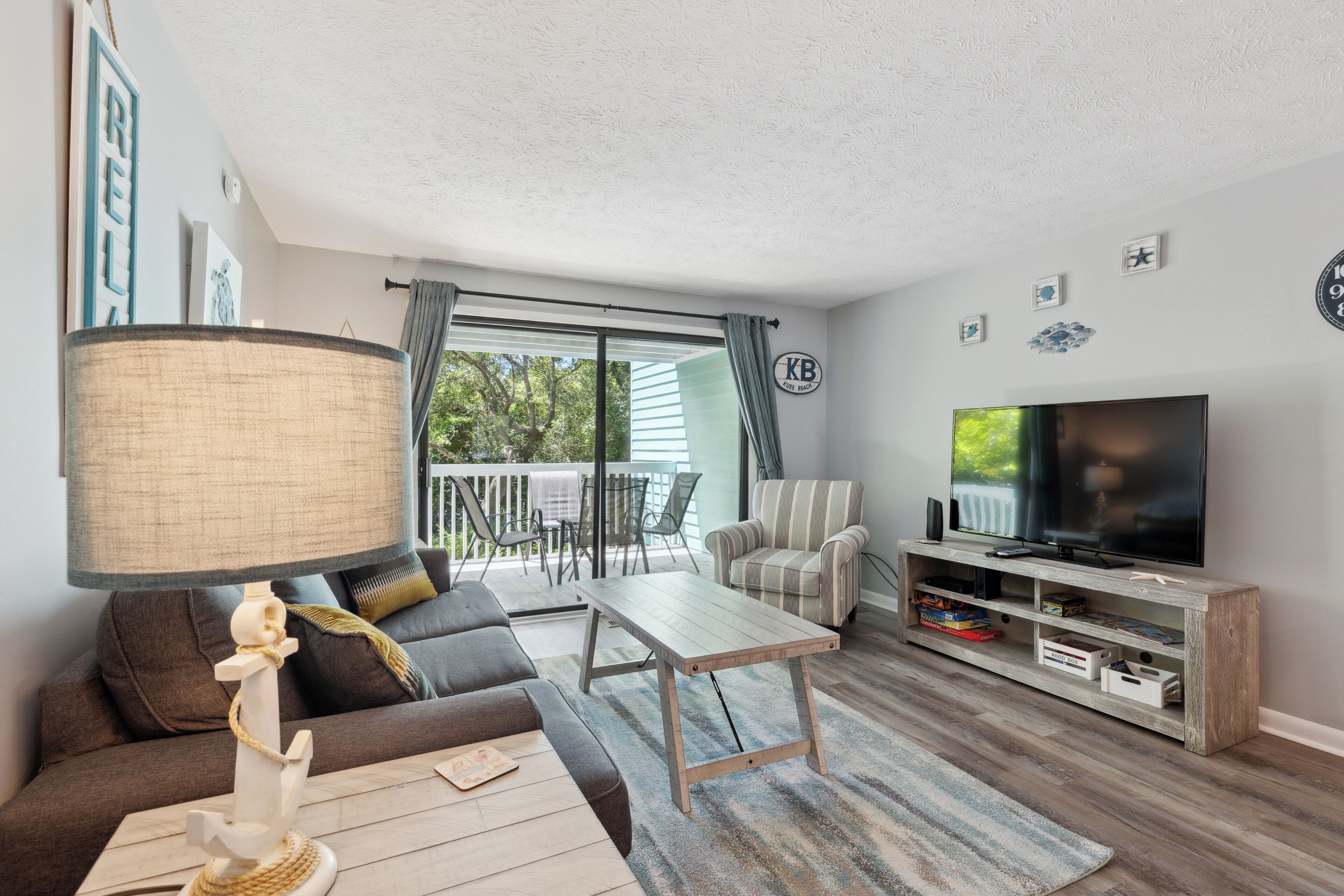Ein Wohnzimmer mit Sofa, Couchtisch, TV-Schrank und einer Lampe.