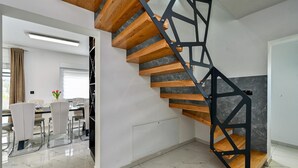Un interior moderno con escalera de madera y zona de comedor.