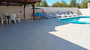 A pool area with lounge chairs, a table, and a pergola. - Lovely home in Benkovac (Benkovac)