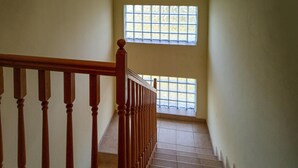 A staircase with wooden balusters and a handrail, leading to a landing with a view of a window with a grid pattern. - Lovely home in Benkovac (Benkovac)