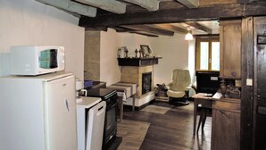 Una cocina equipada con microondas, refrigerador, estufa y chimenea.