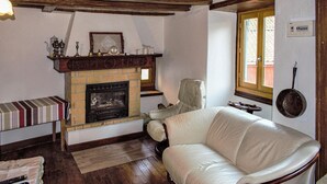 Una sala de estar acogedora con chimenea, un sofá de cuero y techo de madera.