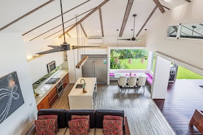 Eine moderne Küche mit Essbereich, Deckenventilator und Gartenblick.
