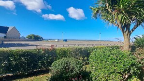 A parking lot with a building in the background, a palm tree, and a clear blue sky. - CARNAC - Apartment 2 rooms - 4/5 persons - Terrace Sea View (CARNAC)