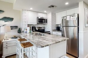 Enjoy cooking in this well-equipped kitchen with a sink, microwave, and refrigerator.