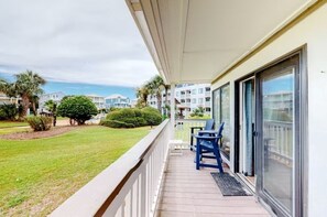 Enjoy the serene view from this hotel's balcony, overlooking a lush lawn and neighboring buildings.