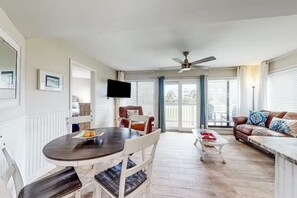 Relax in this stylish living area with a round table, flat-screen TV, and comfortable sofa.