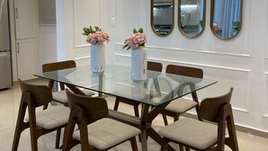 Un espace repas moderne avec une table en verre, des chaises en bois et un design minimaliste.