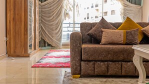 A living room with a brown sofa, yellow cushions, a red rug, and a wooden cabinet. - Modern & Large Studio in Casablanca - Bd Anfa (Casablanca)