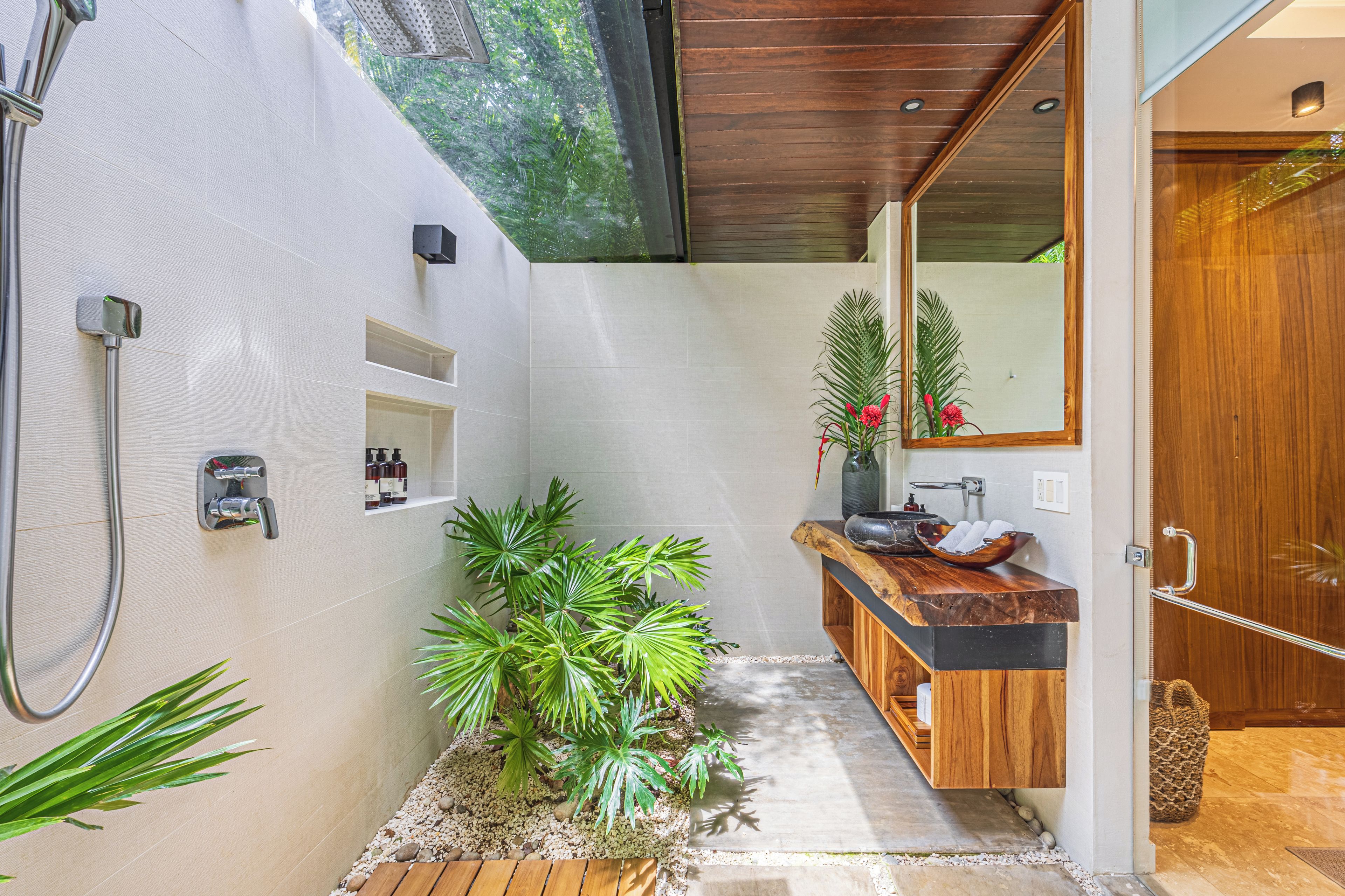 Un bagno moderno con un mobile vanitario in legno, un ampio specchio e un angolo doccia.