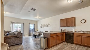 A modern kitchen with wooden cabinets, a stainless steel dishwasher, and a granite countertop.
