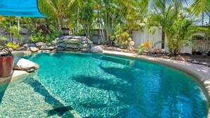 A clear blue pool surrounded by tropical plants and a stone wall. - Ultimate heaven of comfort and relaxation. Entire house, large private pool.  (Kewarra Beach)