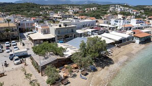 An aerial view of a coastal town with buildings, a beach, and clear skies. - Elena SeaFront Luxury Apartments (Apokoronas)