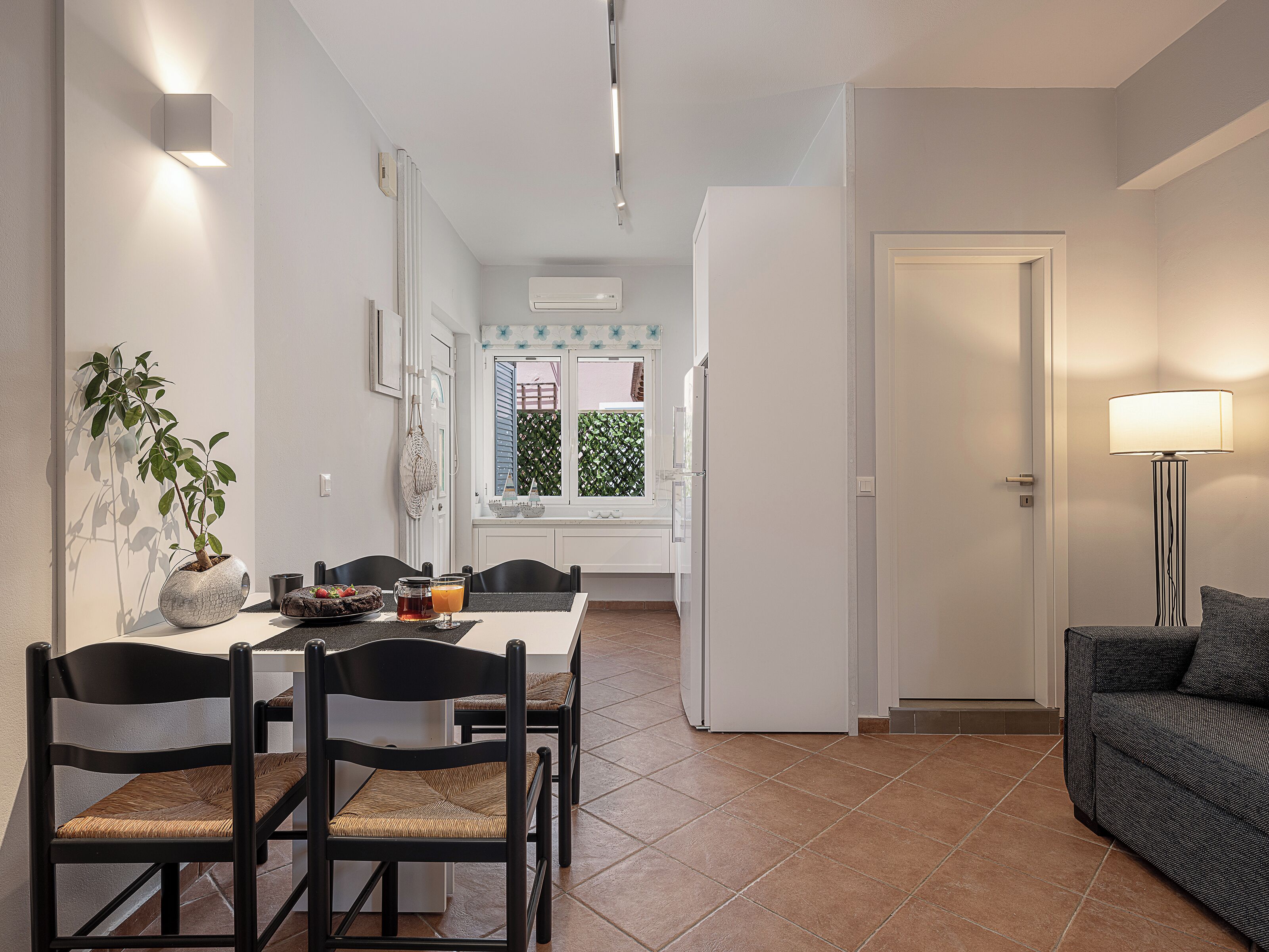 A modern dining area with a table, chairs, and a potted plant.