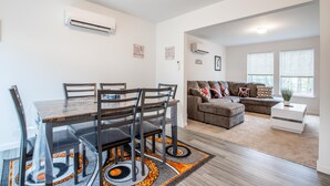 En moderne stue med spiseplads, sofa og et lille sofabord.