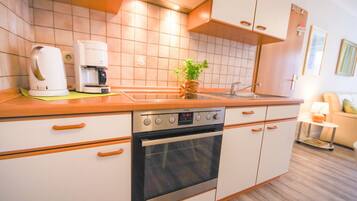 Eine Küche mit Herd, Backofen und Kaffeemaschine.