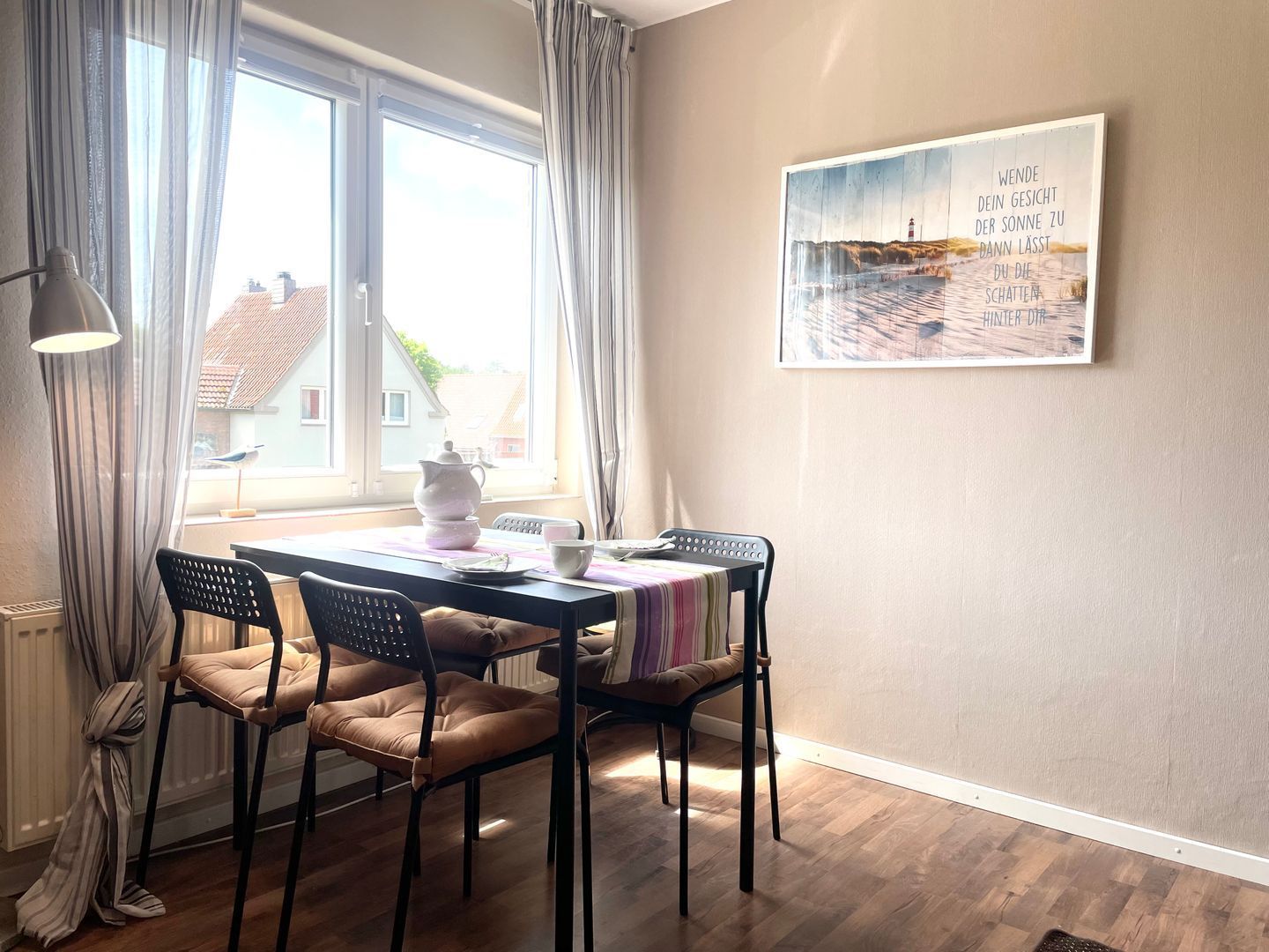 Ein Essbereich mit Tisch, Stühlen und Blick ins Freie.