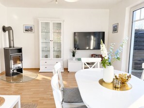 Una sala moderna con chimenea, comedor y televisor.