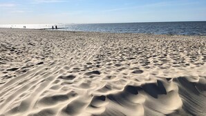 A sandy beach with gentle waves and a clear sky.