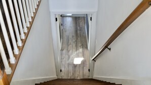 A wooden staircase with white railings leading to a door with a light-colored wall. - 5 minute walk to beach, walk to town & train (Fairfield)