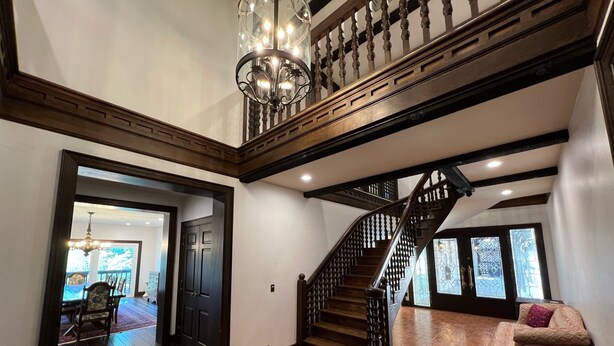 A spacious interior with a grand staircase, a chandelier, and a dining area. - Welcome to The Urban Mansion in Midtown Tallahassee (Tallahassee)