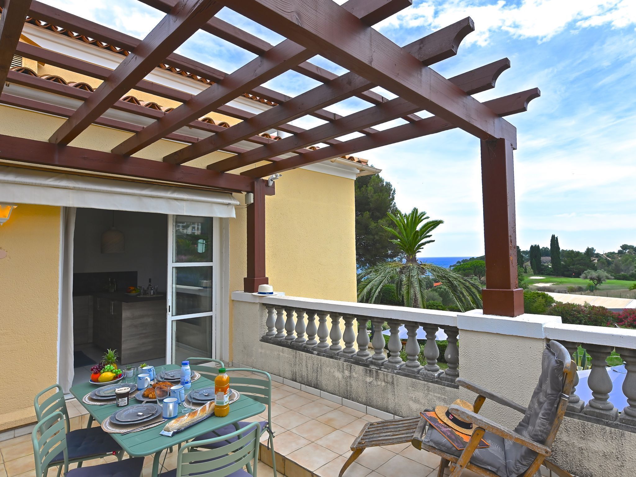 Una terraza con una mesa dispuesta para una comida, una silla y vistas del paisaje.