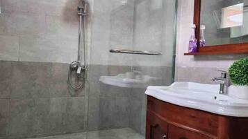 Een douche, handdoeken, zeep, shampoo