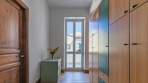 Ein Flur mit Holztüren, einem grünen Schrank und einer Tür mit Glasverkleidung.