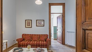 Ein Wohnzimmer mit einer Couch, einem Couchtisch und gerahmten Bildern an der Wand.