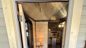 L’entrée de la cabane se compose d’une porte en bois, d’un paillasson et d’un couloir qui mène à une cuisine.