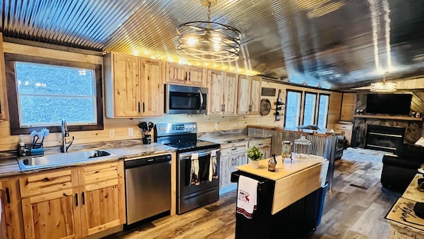 Une cuisine moderne avec des meubles en bois, des appareils électroménagers en acier inoxydable et une grande fenêtre.