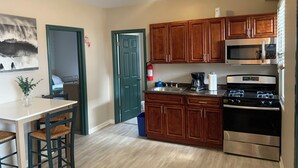 A kitchen with wooden cabinets, a microwave, a stove, and a sink.